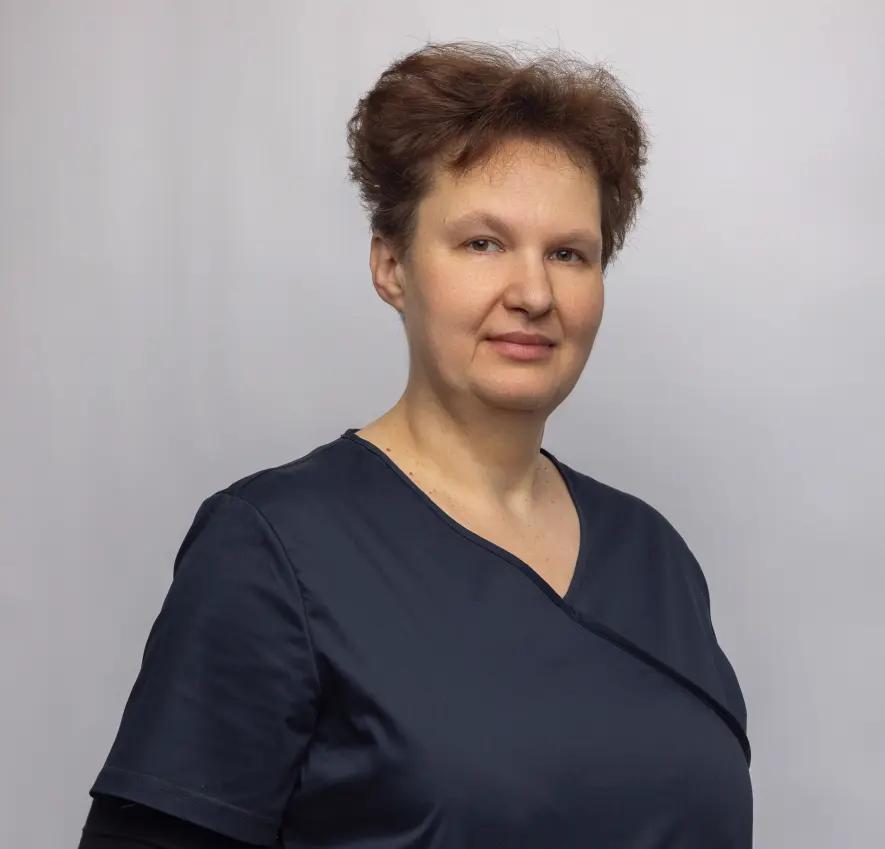 Kobieta w krótkich, brązowych włosach, w ciemnym uniformie na szarym tle