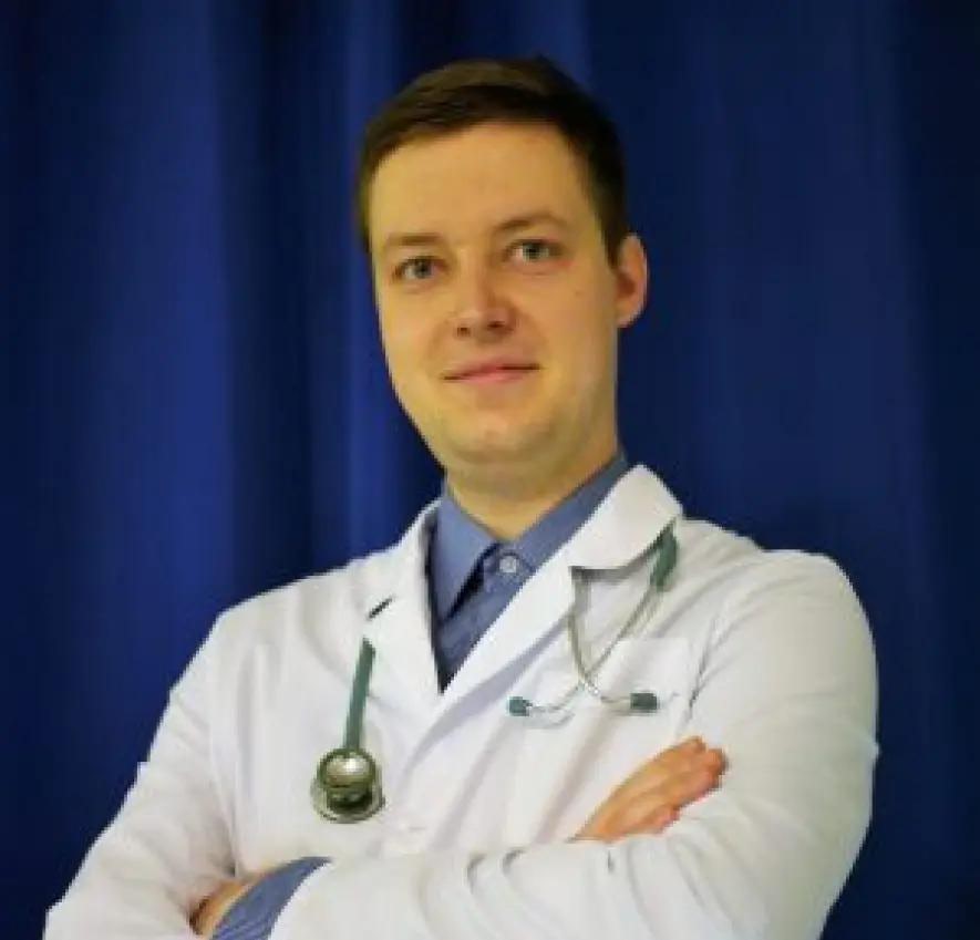 Lekarz Centrum Medycznego Alma Med w niebieskiej koszuli i białym fartuchu ze stetoskopem wokół szyi